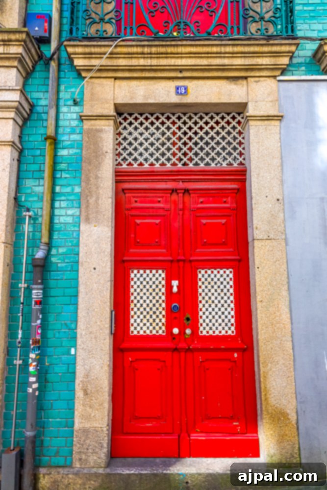 Crafting the Perfect Port and Tonic 21 A charming green tiled building in Porto, Portugal, featuring a striking red door that stands out against the intricate tilework.