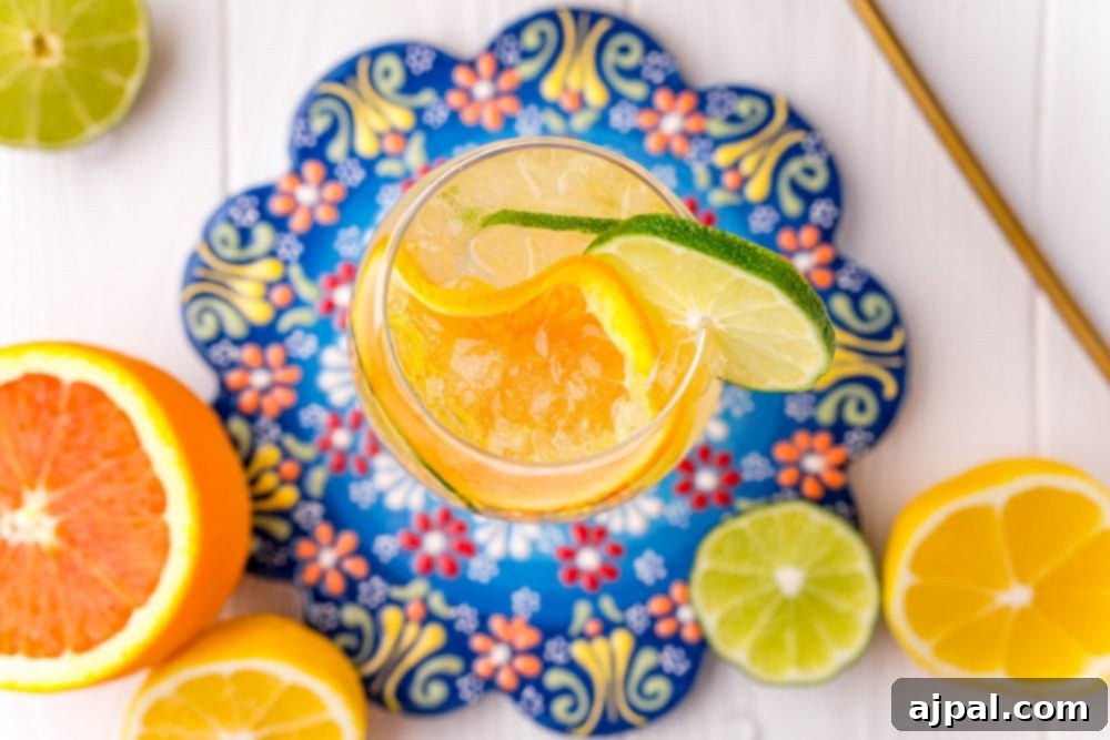 Crafting the Perfect Port and Tonic 4 A close-up of a Port and Tonic cocktail, showcasing vibrant citrus slices of limes and lemons floating amidst the ice and sparkling liquid in a wine goblet.