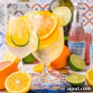 A sparkling Port wine cocktail with orange slices and a bottle of tequila.