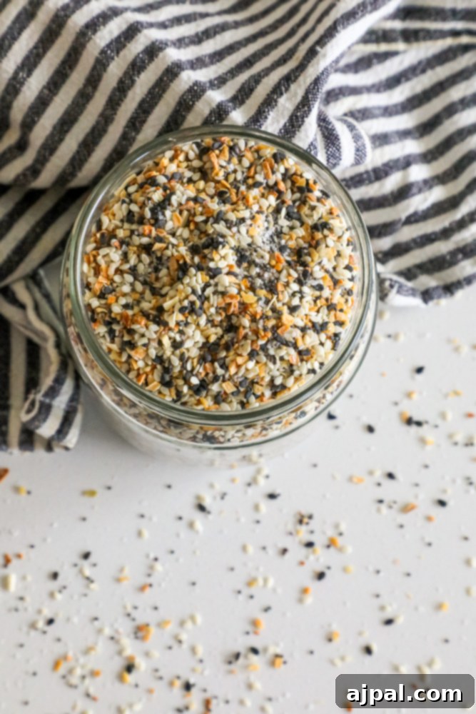 Crafted Everything Bagel Seasoning Blend 3 A beautifully arranged bowl of Everything Bagel Seasoning mix on a rustic table, highlighting its diverse ingredients.