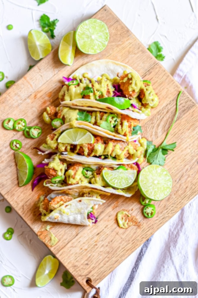 A rustic wooden cutting board showcasing several perfectly pan-fried chicken tacos, ready for serving.