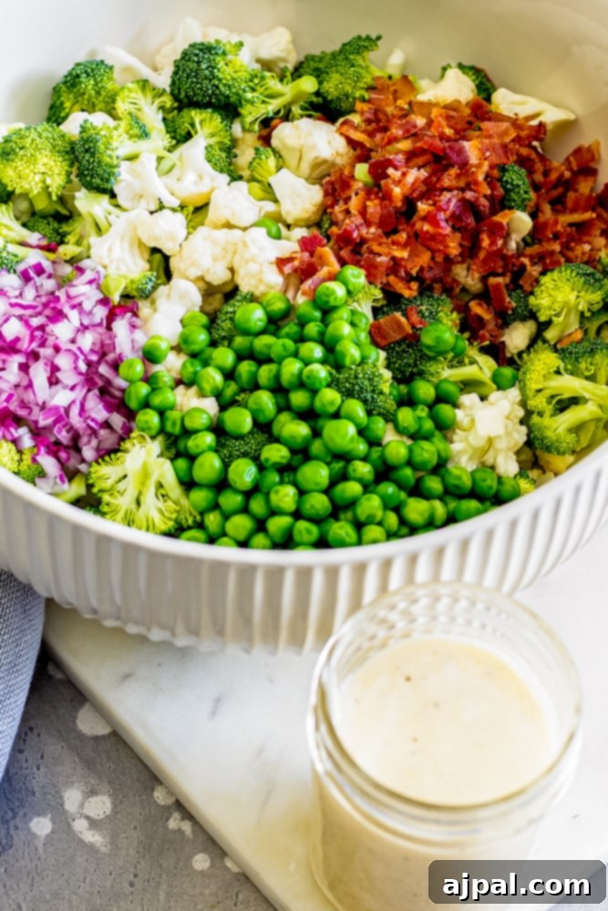 broccoli salad ingredients in a bowl next to a jar of creamy dressing