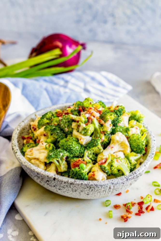 broccoli salad in a bowl and a cutting board with bacon and chives