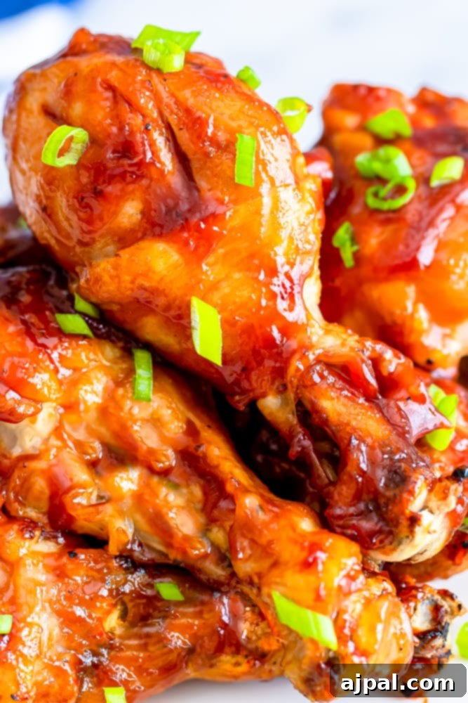 A stunning close-up of BBQ chicken wings on a plate with green onions, perfectly cooked in the Instant Pot, highlighting their appetizing glaze and crispy skin.