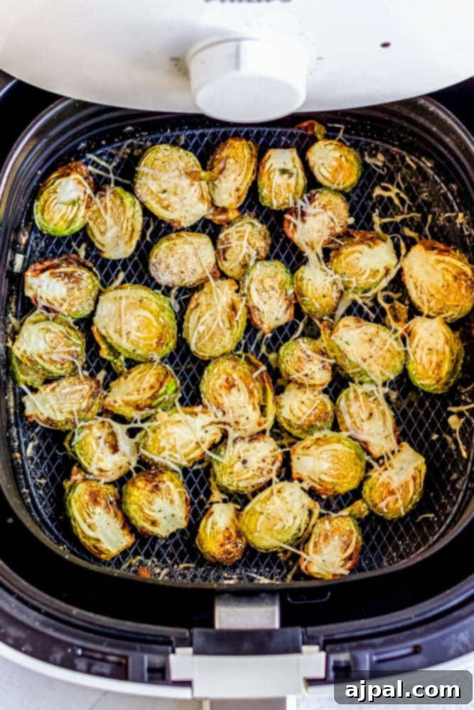 Crispy Keto Air Fryer Brussels Sprouts 9 cooked brussels in an air fryer basket, golden brown