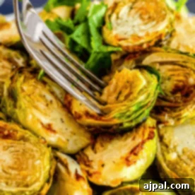 Crispy Keto Air Fryer Brussels Sprouts 12 A fork piercing roasted Brussels sprouts garnished with parsley