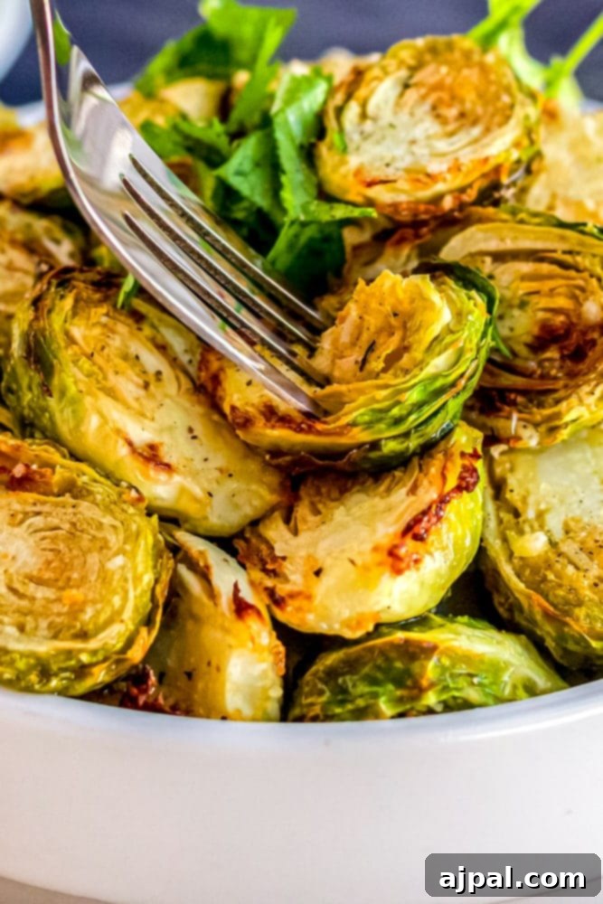 Crispy Keto Air Fryer Brussels Sprouts 5 picture of a fork going into a bowl of air fried brussels sprouts, keto friendly