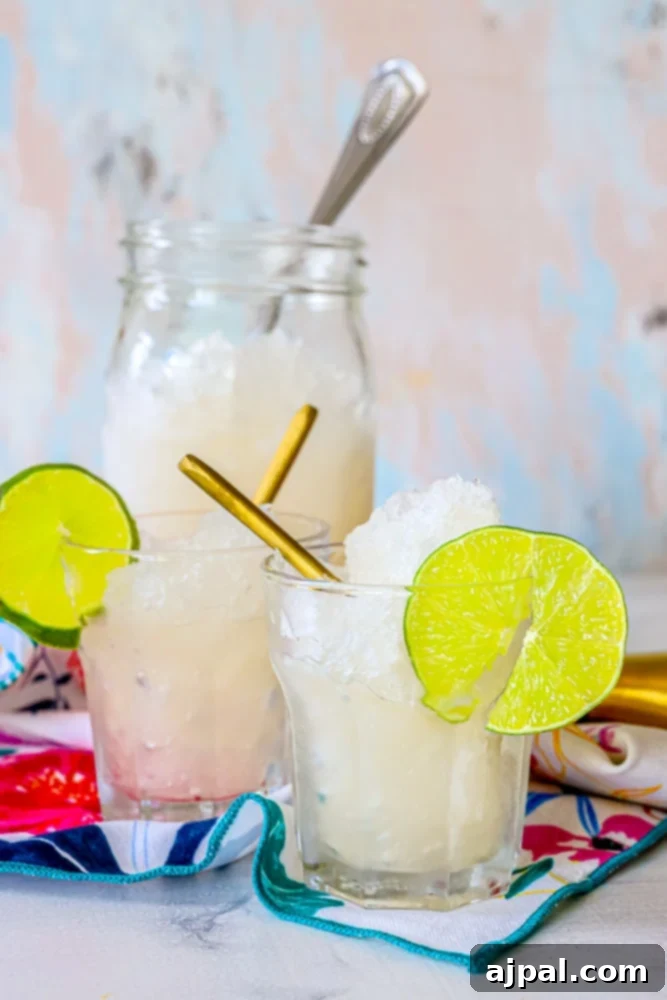 Two jars of granita-style gin and tonic, perfectly chilled and garnished with vibrant lime slices, presenting a refreshing and elegant summer beverage.