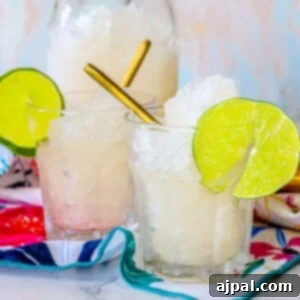 Three glasses of easy frozen gin and tonic slush with lime wedges.