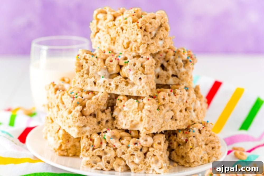 A delectable stack of golden Cheerio treats, lightly speckled with colorful sprinkles, resting on a pristine white plate, with a glass of refreshing milk in the soft-focus background.
