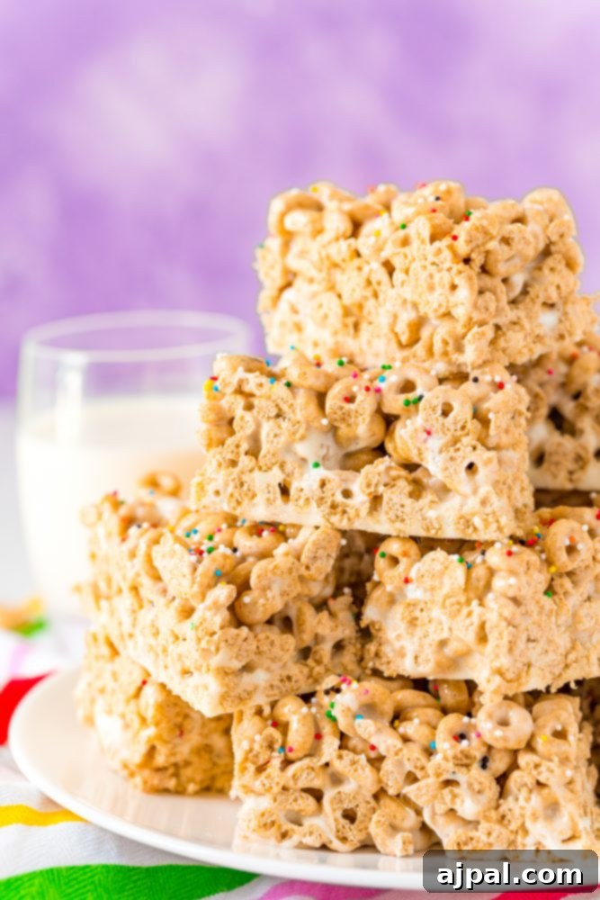A stack of Cheerios Treats on a plate with a refreshing glass of milk, suggesting a delightful snack.