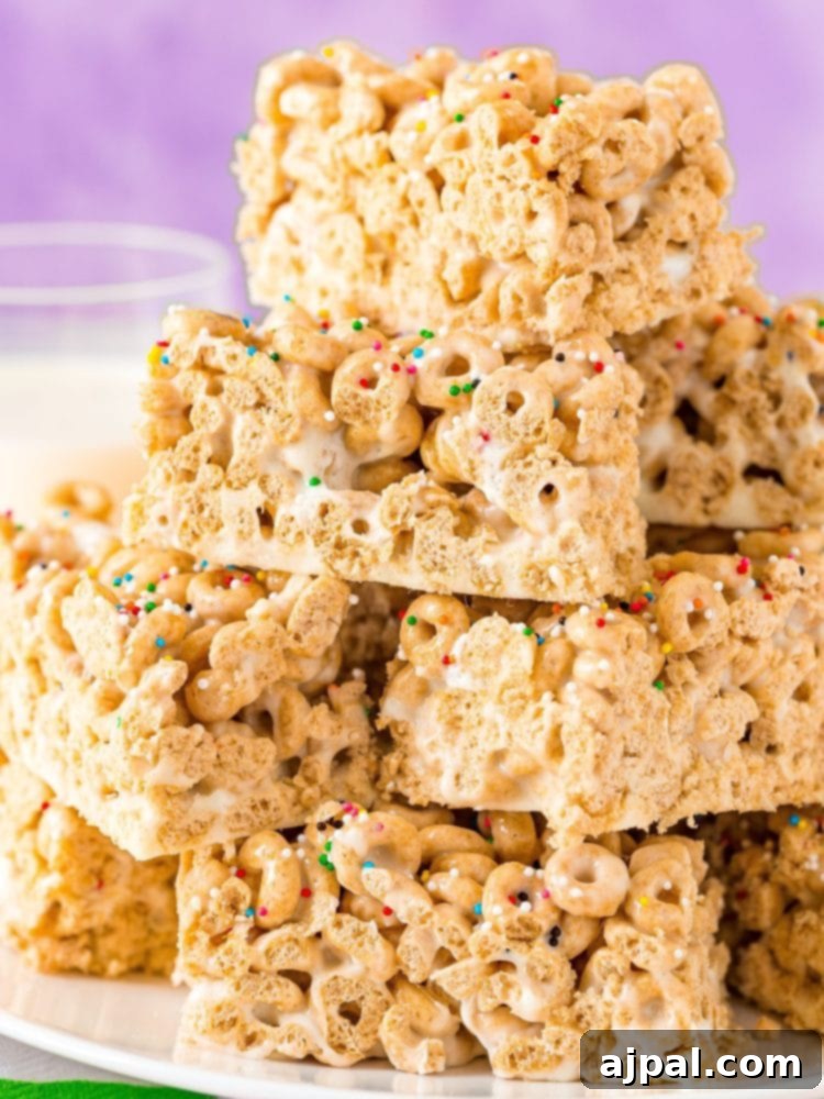 A close-up of a single Cheerio treat bar, showcasing its crunchy texture and colorful sprinkles, held against a vibrant background.