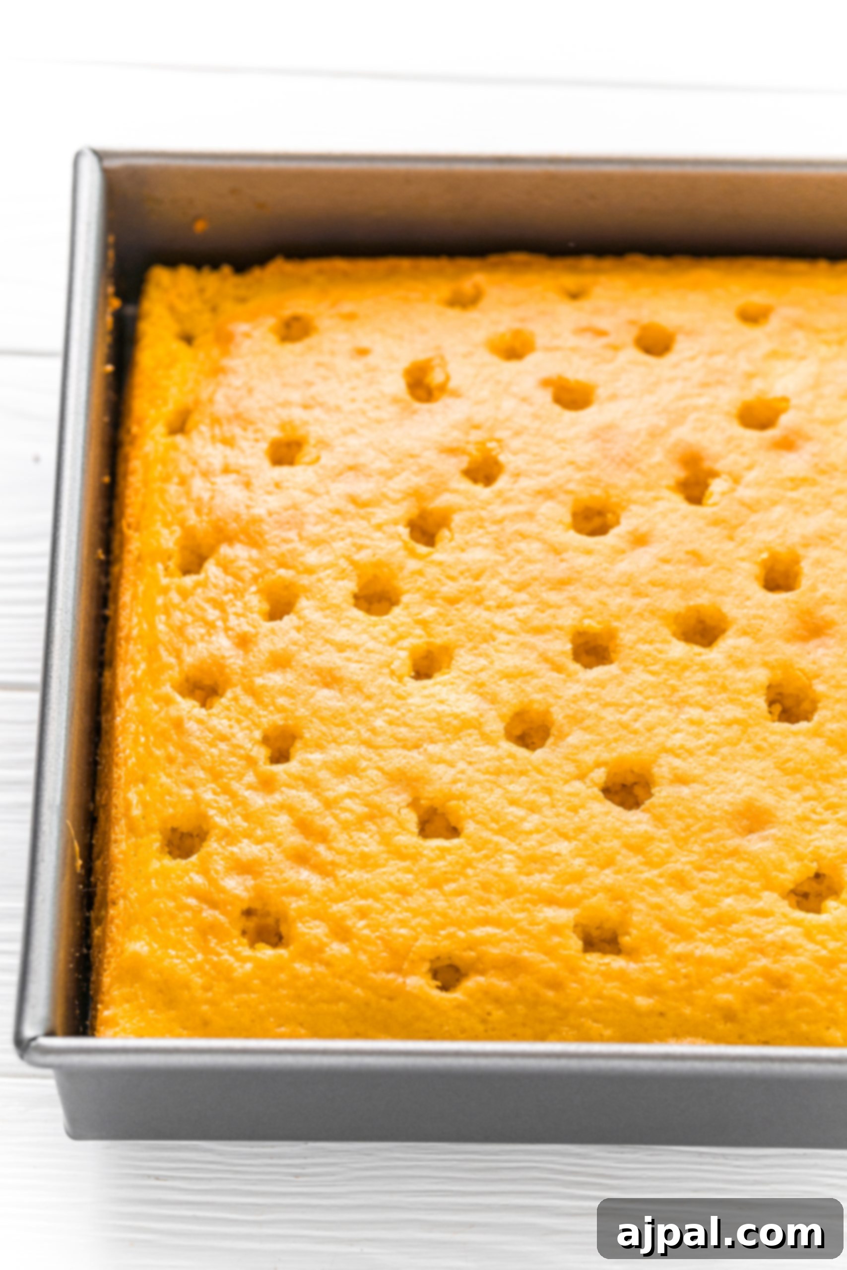 Effortless Lemon Jello Poke Cake 5 Easy Lemon Jello Poke Cake Recipe with a square cake in a baking pan.