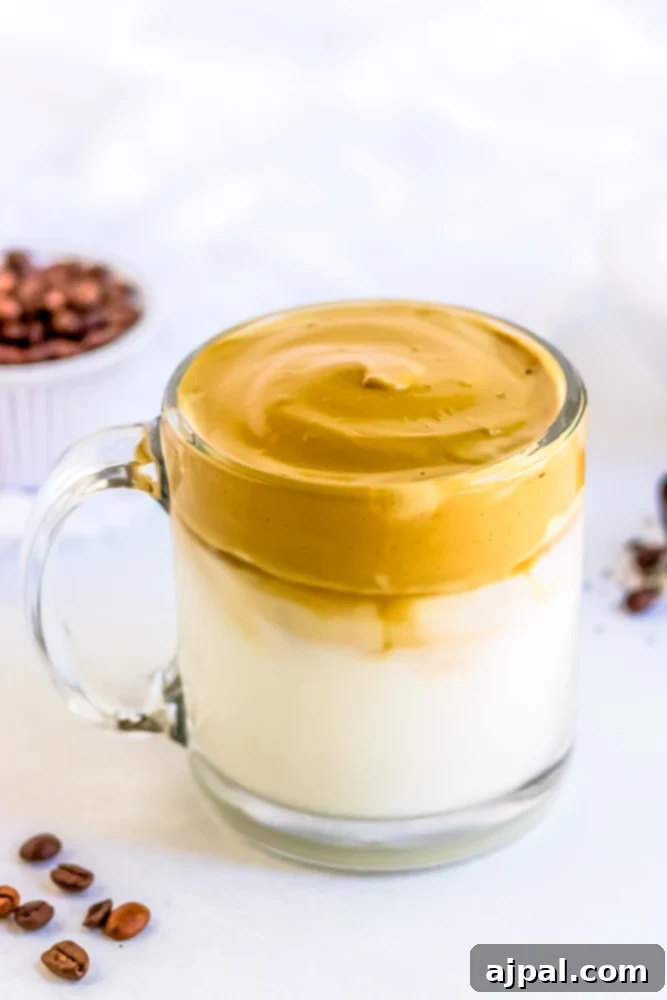 A cup of keto-friendly whipped cream-topped coffee with scattered coffee beans around it.