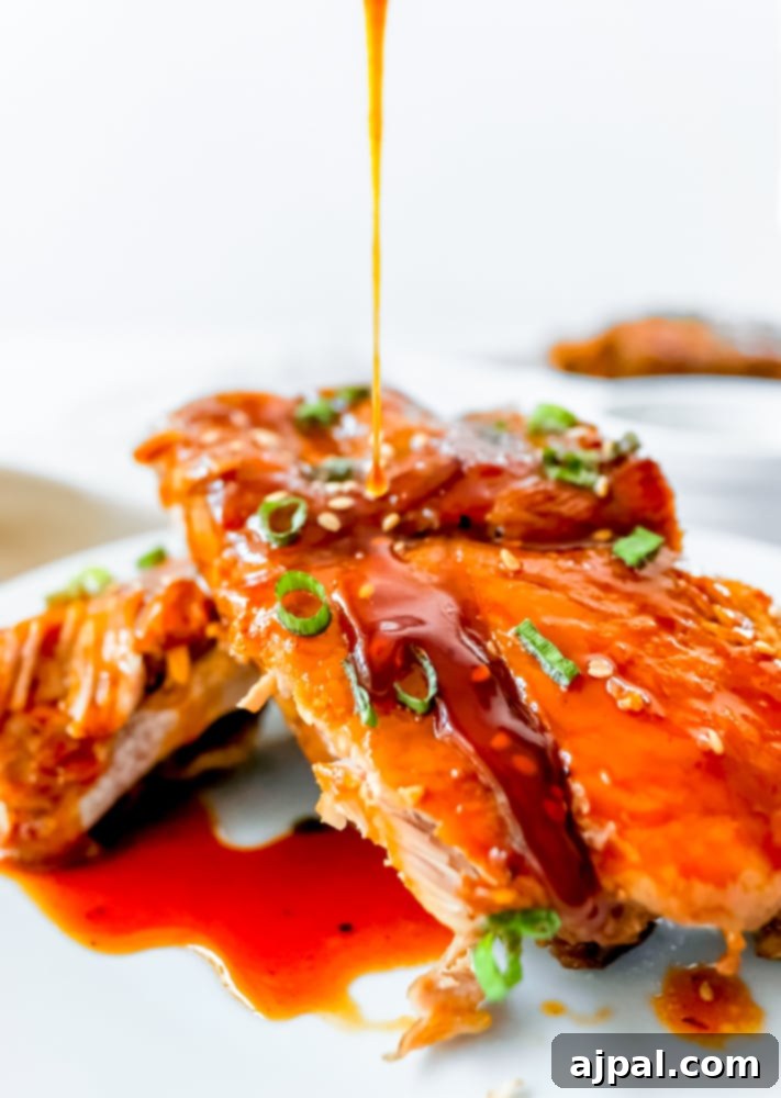 Instant Pot Sticky Asian BBQ Ribs 8 A beautifully arranged plate of Instant Pot Asian Sticky Ribs being drizzled with more sauce for a final touch.