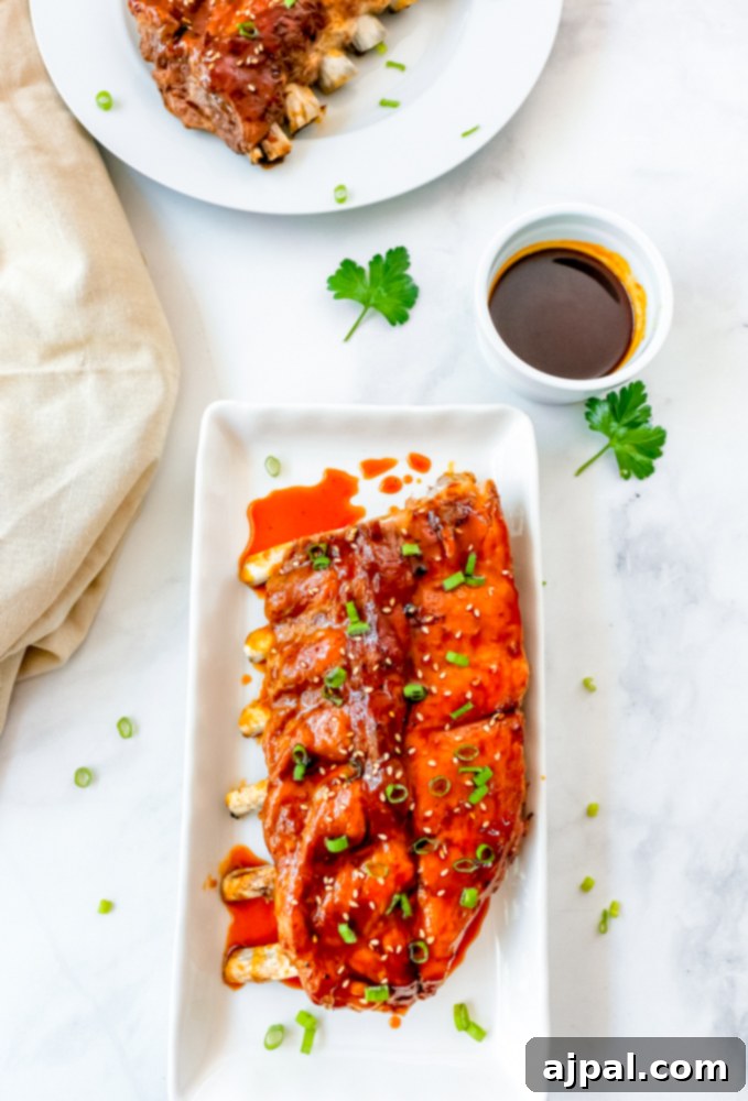 Instant Pot Sticky Asian BBQ Ribs 10 A white plate showcasing a portion of sticky Asian ribs, perfectly glazed and ready to be served.