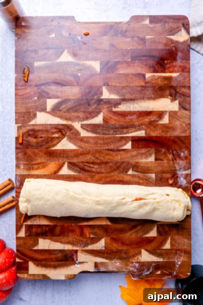 Easy Instant Pot Pumpkin Cinnamon Rolls 12 roll of dough sitting on a wooden cutting board