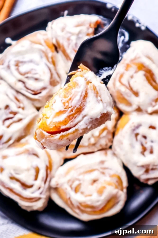 Easy Instant Pot Pumpkin Cinnamon Rolls 21 picture of a fork with cinnamon roll with a bite out of it