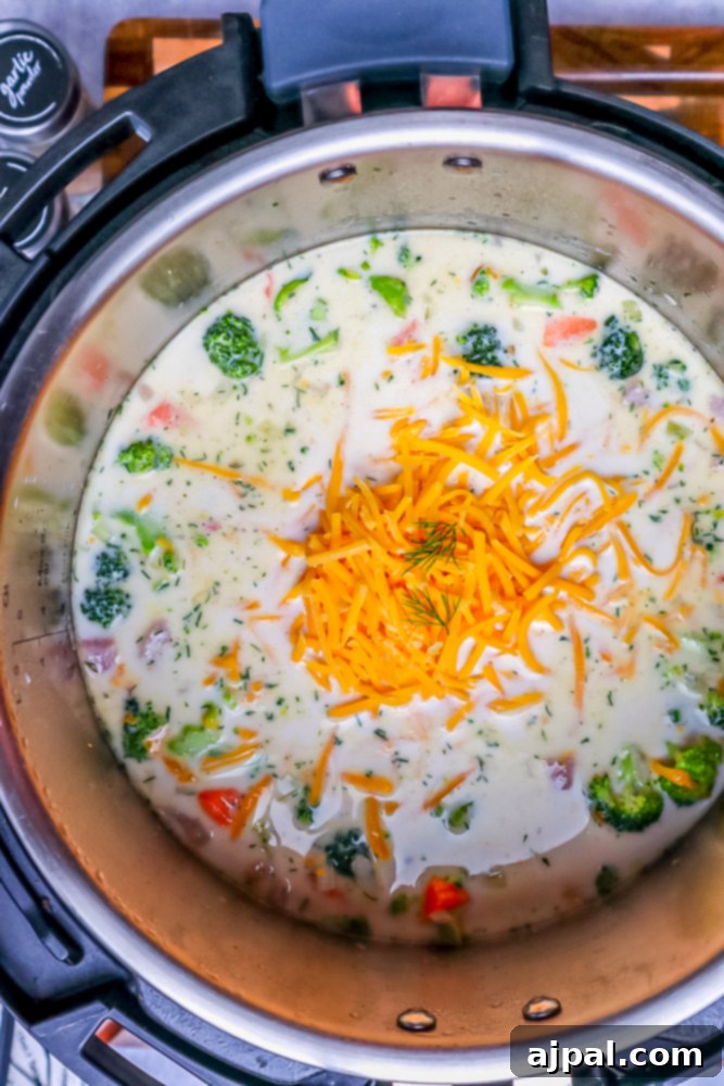 Creamy Instant Pot Keto Broccoli Cheddar Soup 11 Rich cheddar cheese being stirred into the hot Instant Pot soup, melting to create a smooth, creamy, and flavorful base.