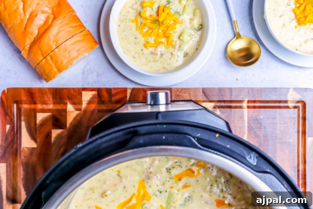 Creamy Instant Pot Keto Broccoli Cheddar Soup 4 A heartwarming scene: a bowl of keto broccoli cheddar soup, garnished and served with crusty bread, next to an Instant Pot, ready for a comforting meal.