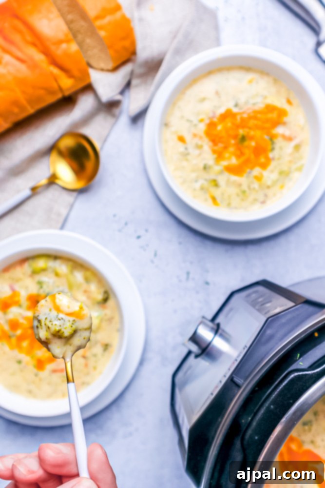 Creamy Instant Pot Keto Broccoli Cheddar Soup 5 A spoon laden with rich keto broccoli cheddar soup, poised above an Instant Pot, highlighting the soup's enticing texture and ready-to-serve appeal.