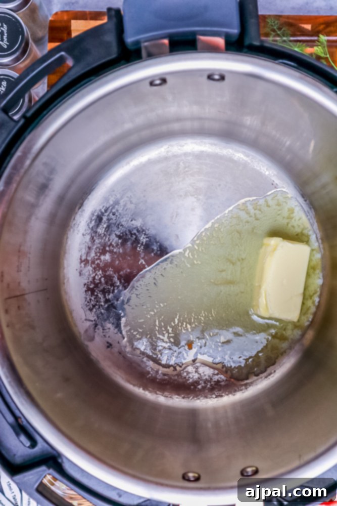 Creamy Instant Pot Keto Broccoli Cheddar Soup 6 Butter melting in the Instant Pot, forming a glistening golden pool at the bottom of the cooking pot.
