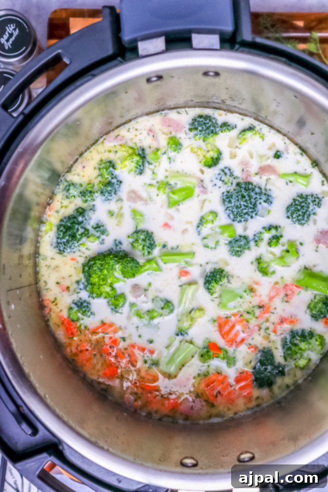Creamy Instant Pot Keto Broccoli Cheddar Soup 10 Diced carrots being introduced to the Instant Pot contents, adding a touch of sweetness and color to the soup base.