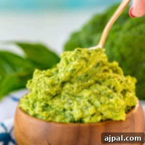 Easy and Delicious Broccoli Pesto 12 A bowl of broccoli pesto with a wooden spoon, showcasing a delicious recipe for broccoli pesto.