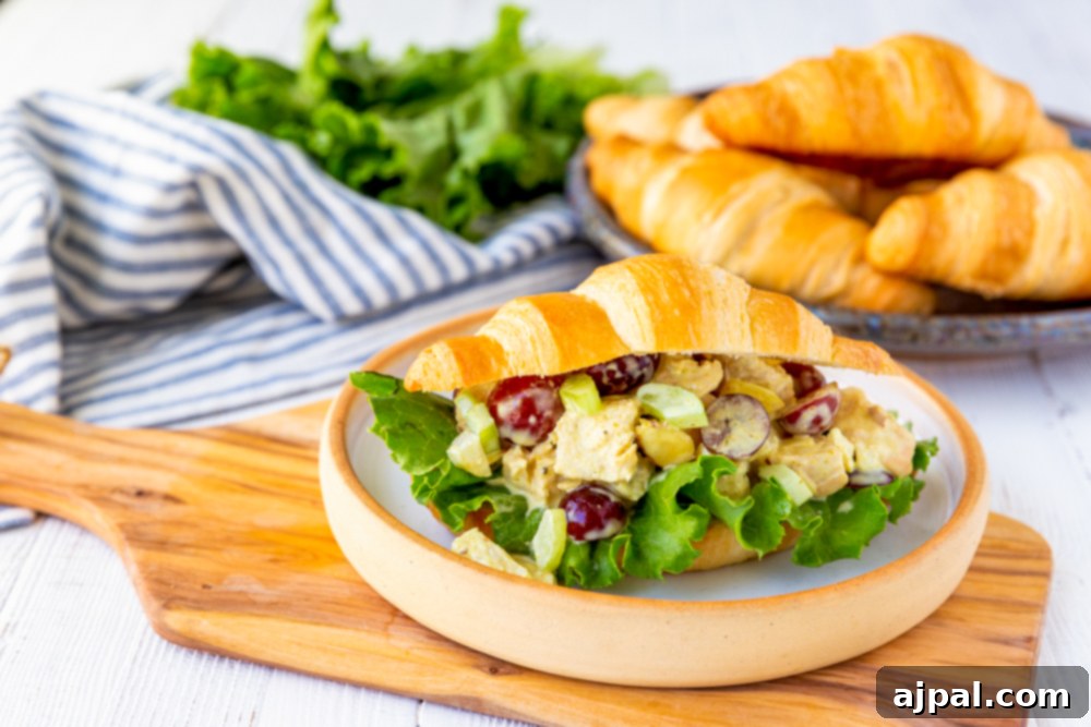 A delicious chicken salad sandwich on a plate with fresh greens