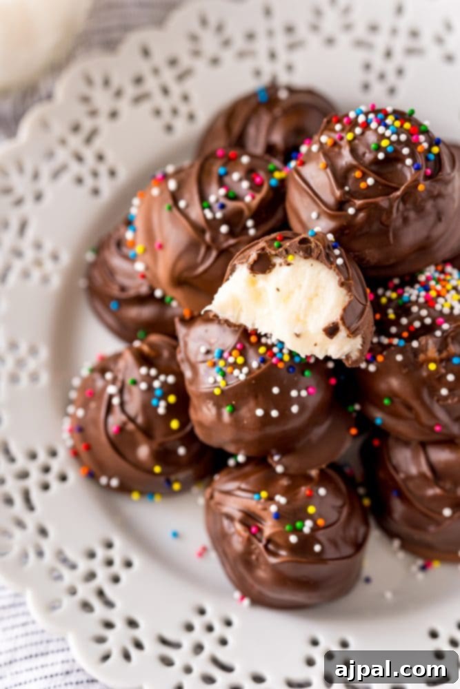 Buttercream candies dipped in chocolate with colorful sprinkles arranged on a pristine white plate, showcasing their delightful appearance.