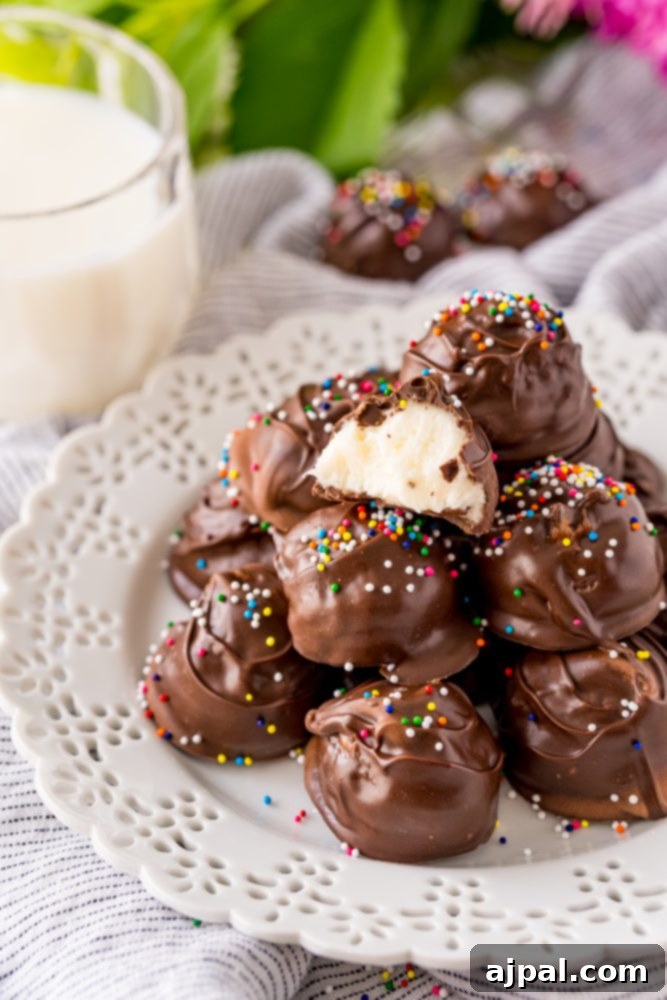 A delightful display of chocolate-dipped buttercream candies with sprinkles on a white plate, ready to be enjoyed.