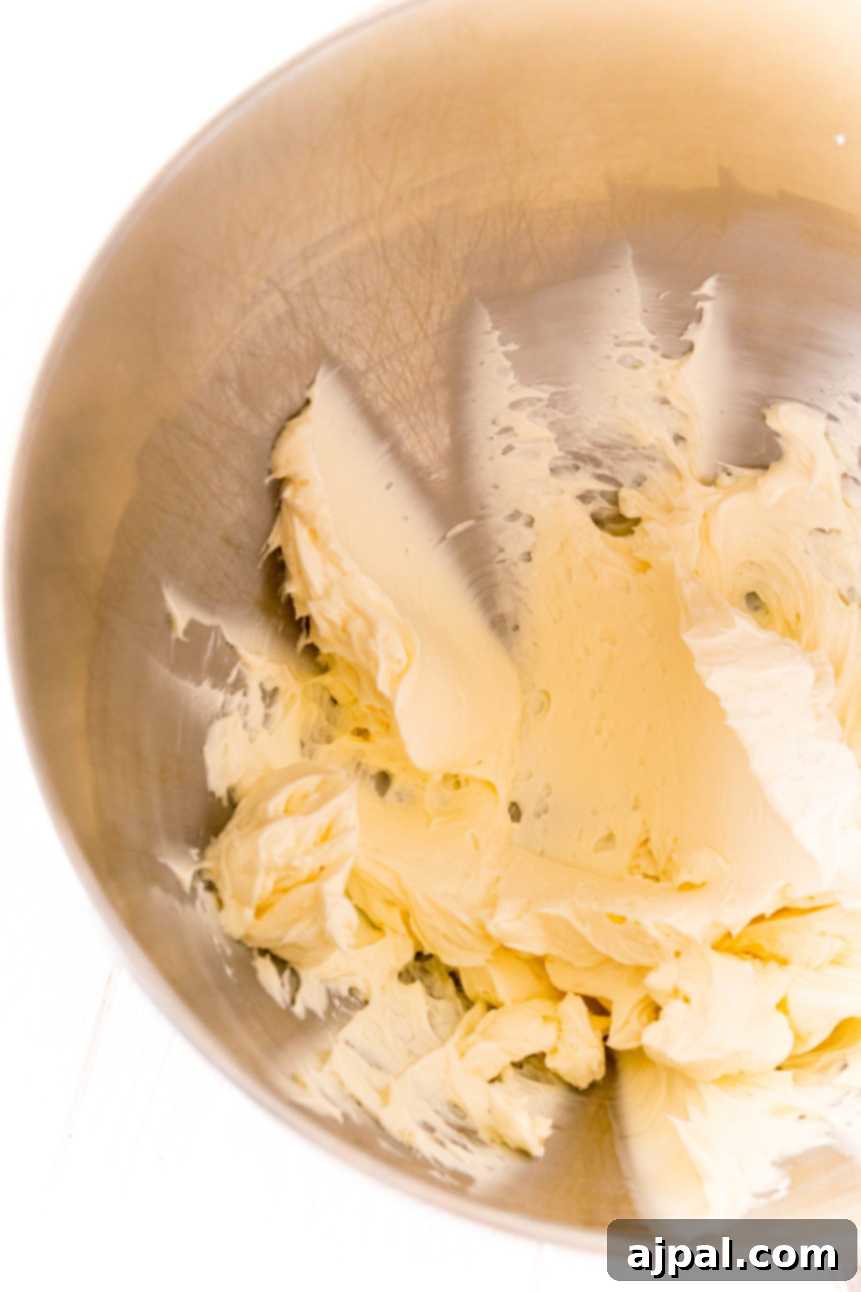 Butter and sugar being mixed together in a bowl.