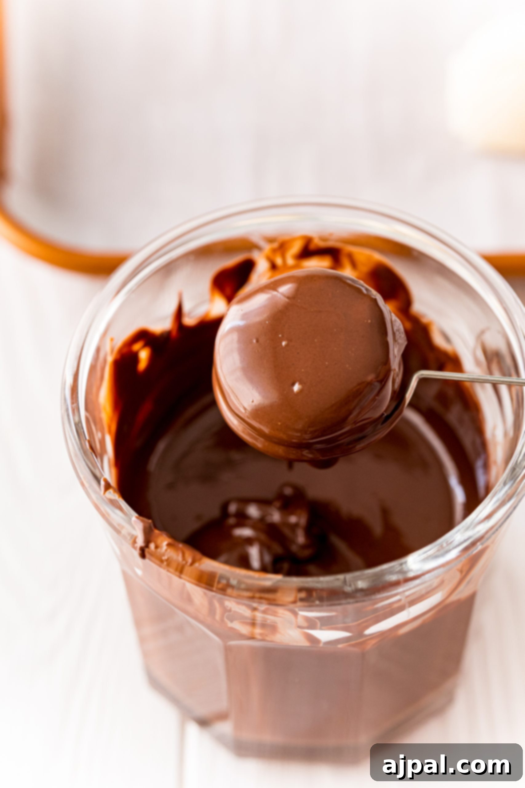A freshly chocolate-dipped buttercream candy, glossy and ready for sprinkles.