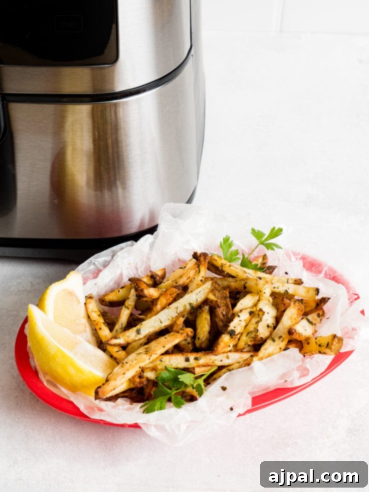 Basket of golden crispy lemon garlic air fryer French fries, perfectly seasoned and ready to serve.
