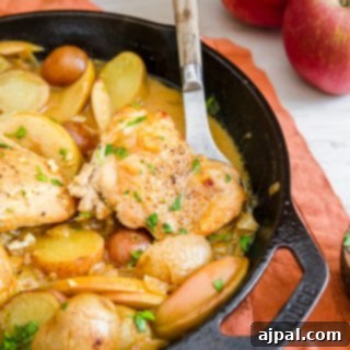 A one-pot skillet dinner featuring Dijon chicken thighs, potatoes, and apples.