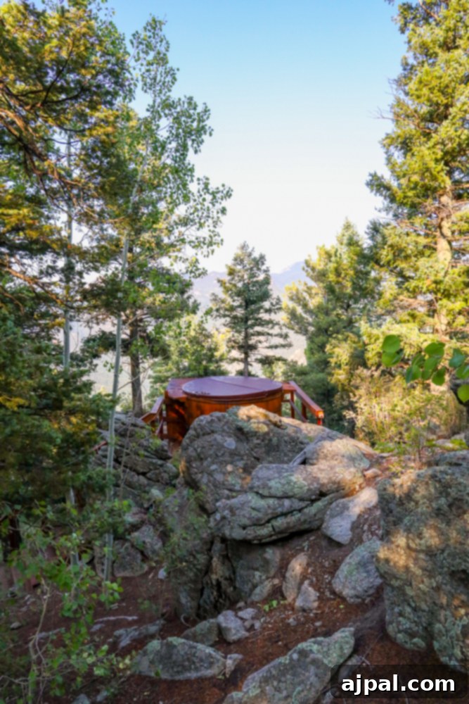 A luxurious wooden cabin featuring an inviting hot tub, nestled on a rocky cliff with stunning views.