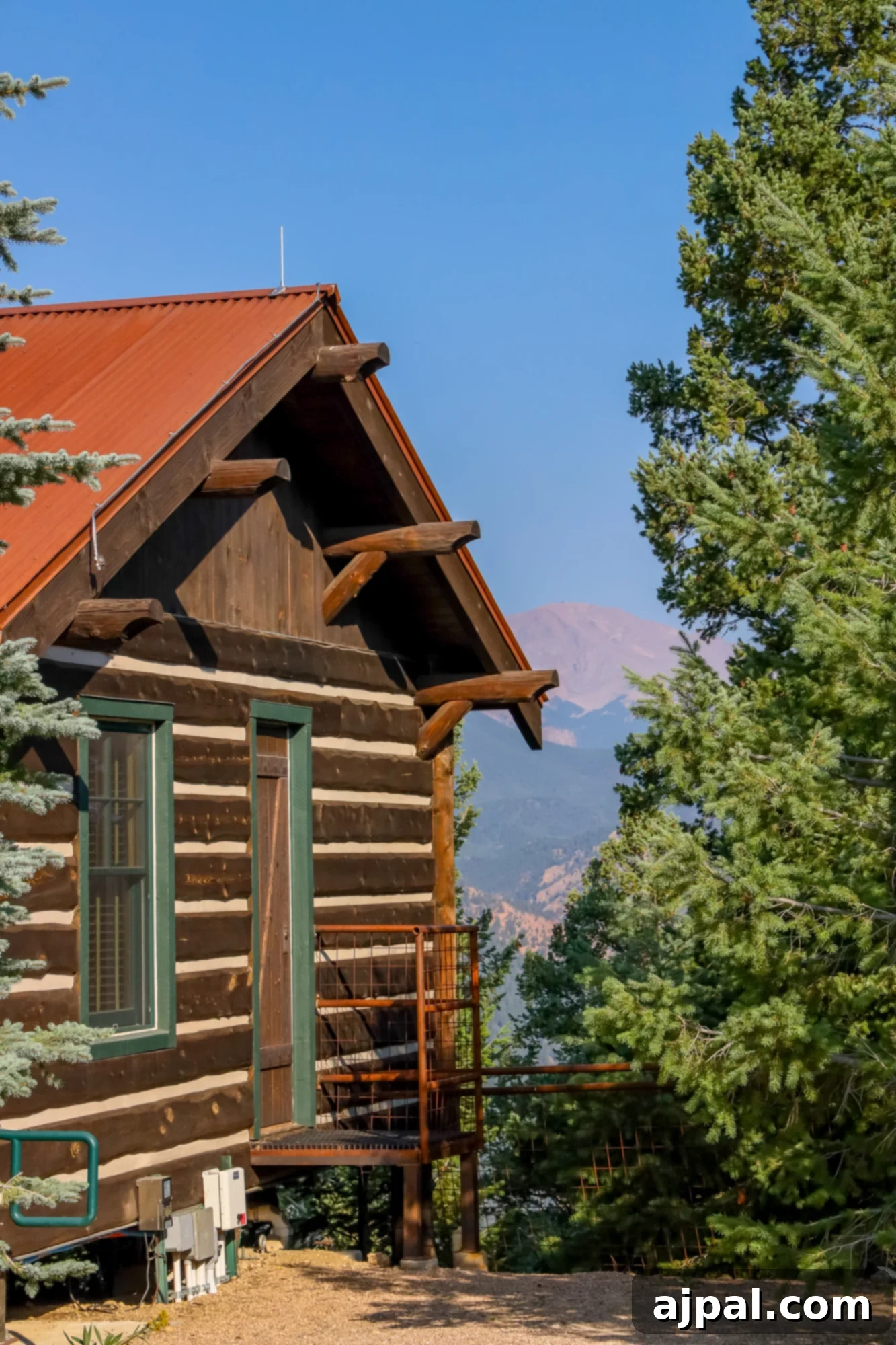 A charming cabin at Cloud Camp, with the majestic Pikes Peak rising in the background.