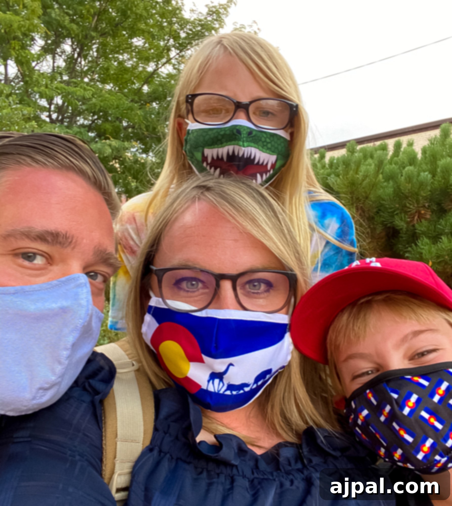 A family wearing face masks, prioritizing safety during their Colorado trip.