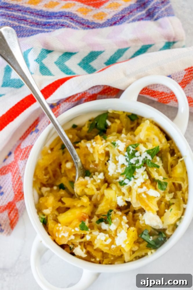A white bowl holds a delicious serving of green chile spaghetti squash, ready to be enjoyed with a spoon.
