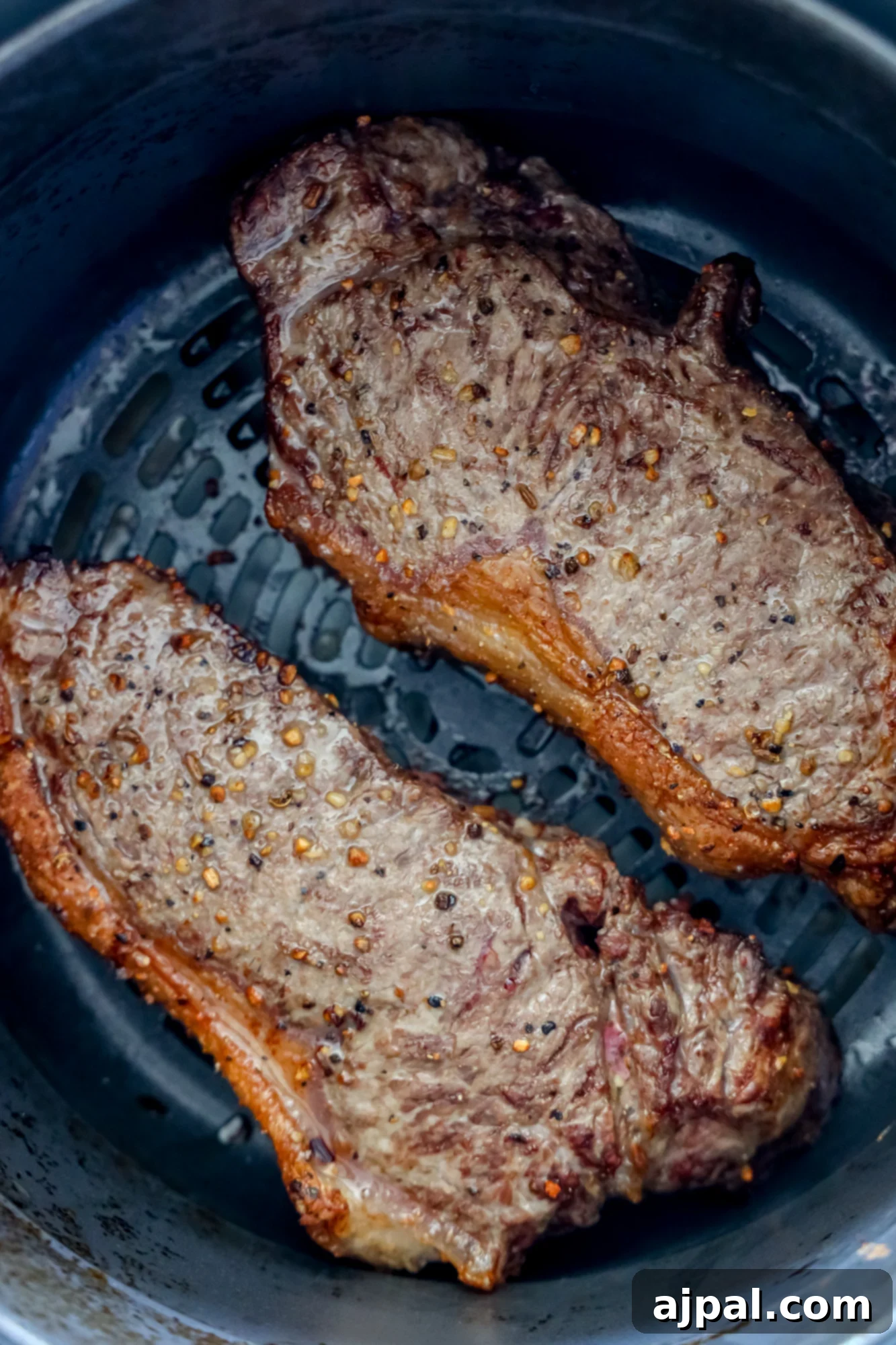Master Your Air Fryer Steaks 7 Two perfectly air-fried steaks with a beautiful crust, just removed from the air fryer.