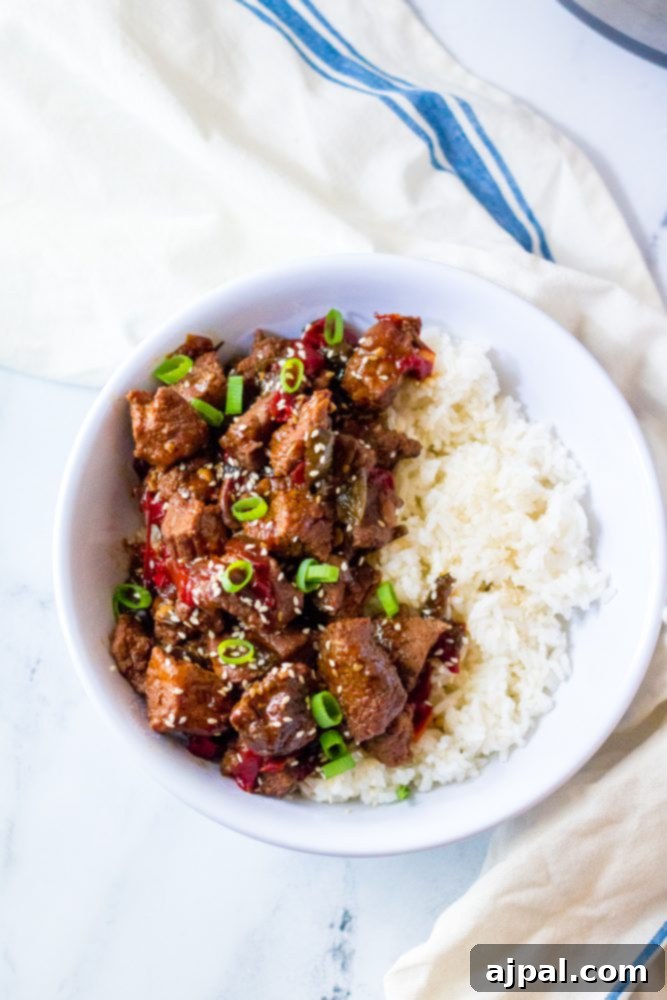 Quick & Flavorful Instant Pot Korean Beef 6 picture of korean beef in a bowl with scallions and rice, garnished with sesame seeds