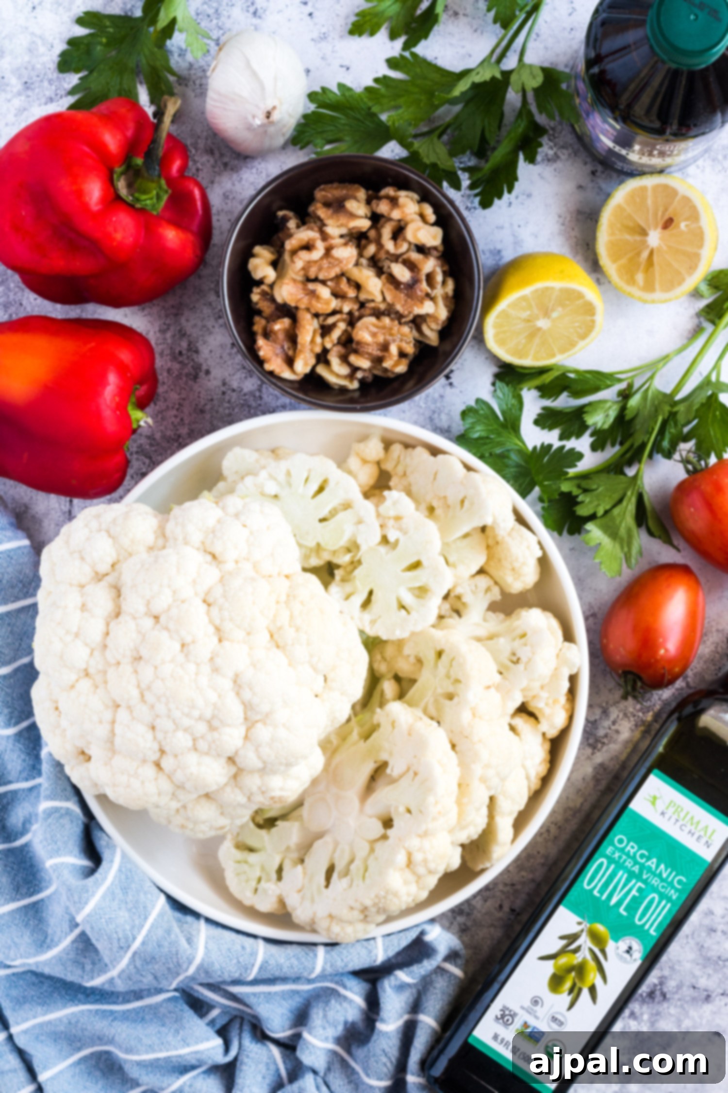 Effortless Cauliflower Steaks with Tangy Red Pepper Sauce 10 A bowl of marinated vegan cauliflower steaks and red peppers, ready for grilling or roasting.