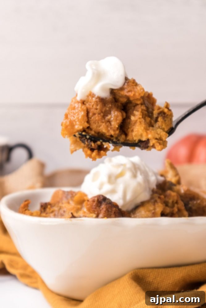 Slow Cooker Pumpkin Bread Pudding: A Cozy Autumn Dessert 10 A serving of pumpkin bread pudding with whipped cream on a fork, showcasing its soft, custardy texture.
