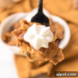 A delicious spoonful of pumpkin pie with whipped cream on top.