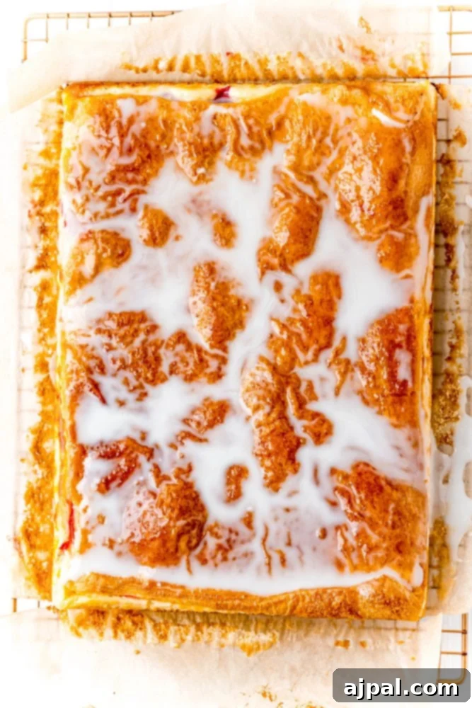 glazed cherry cheesecake pastry on a cooling rack on a table