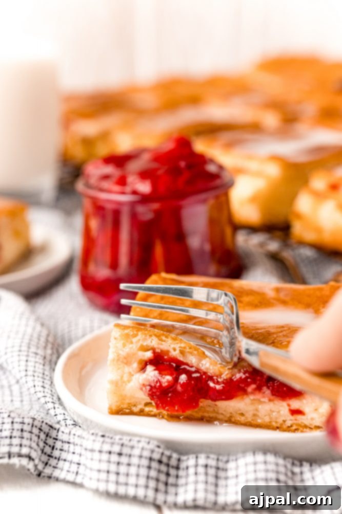 Slice of cherry cheesecake danish on a plate on a table