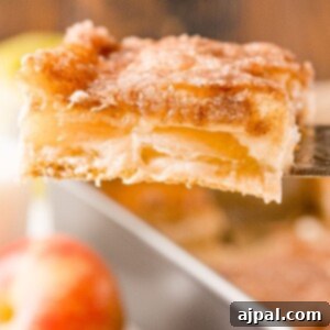 A slice of apple cheesecake bar on a spatula, ready to be served.