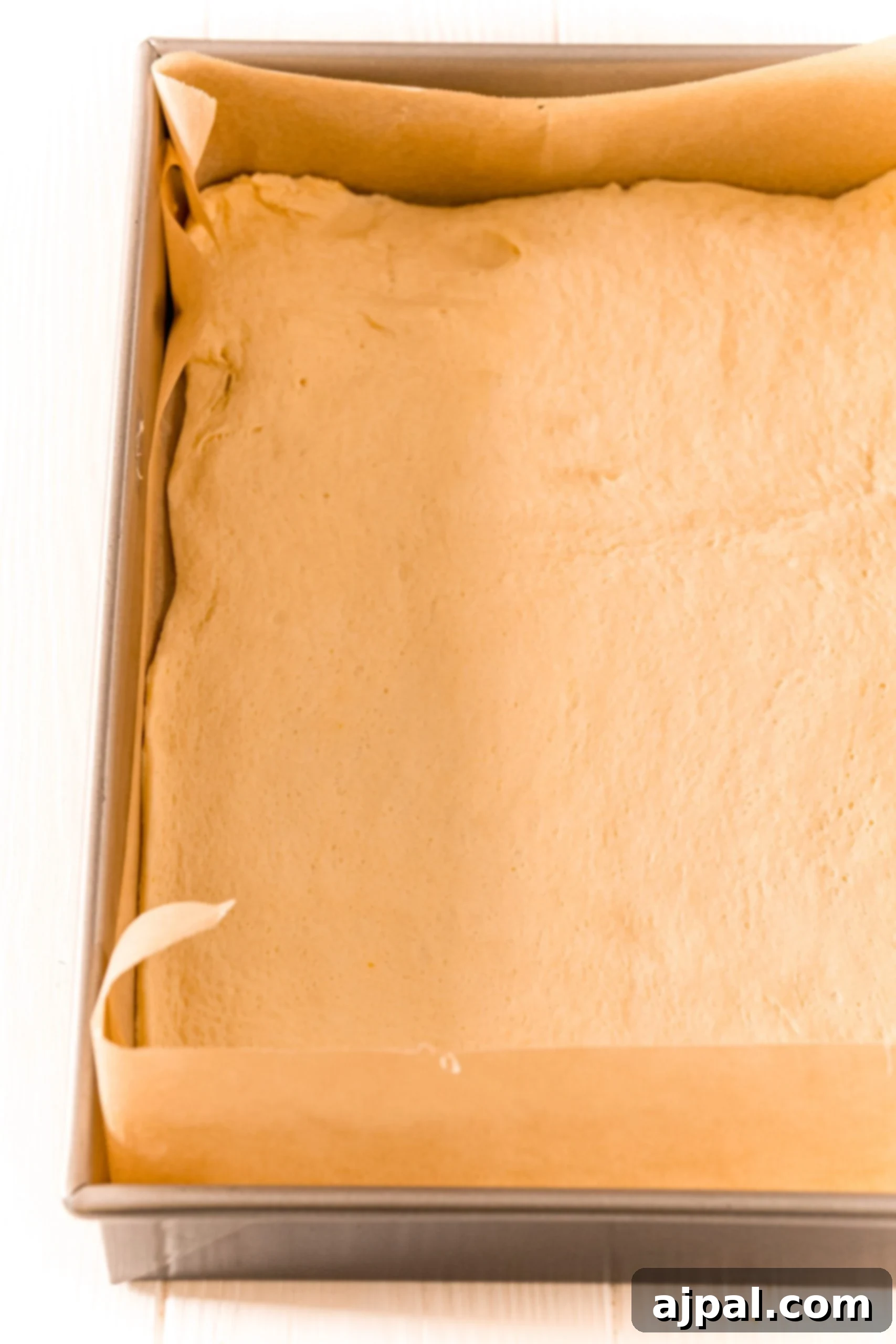 One layer of crescent roll dough pressed into a parchment-lined baking dish.