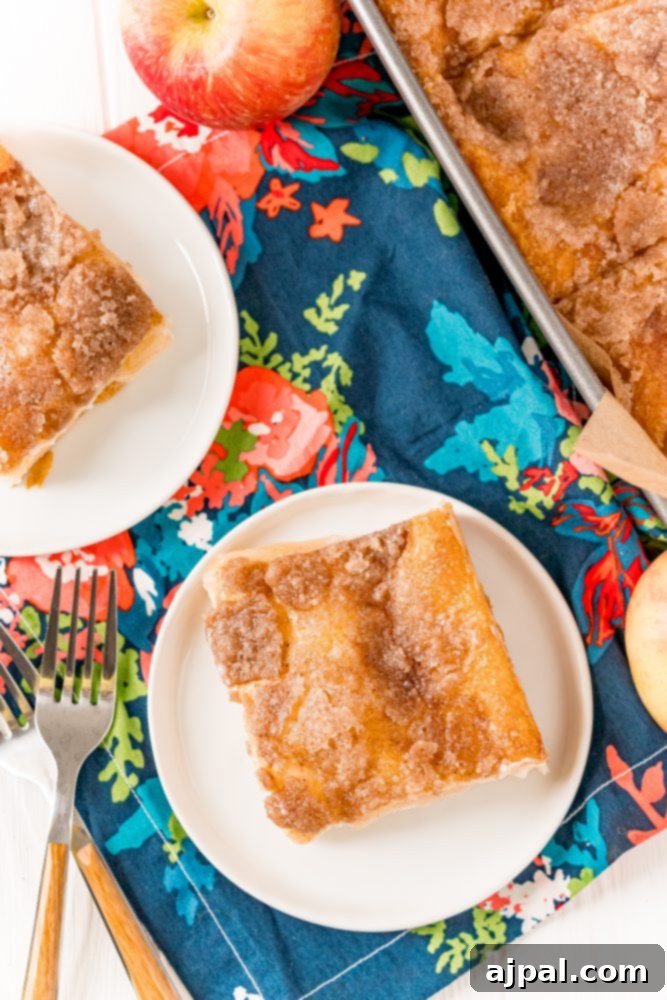 A perfectly portioned slice of baked apple sopapilla cheesecake on a plate with a fork.