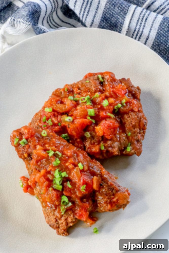 Homemade Swiss Steak: A Step-by-Step Guide 2 steak with outer coating and tomato sauce on top